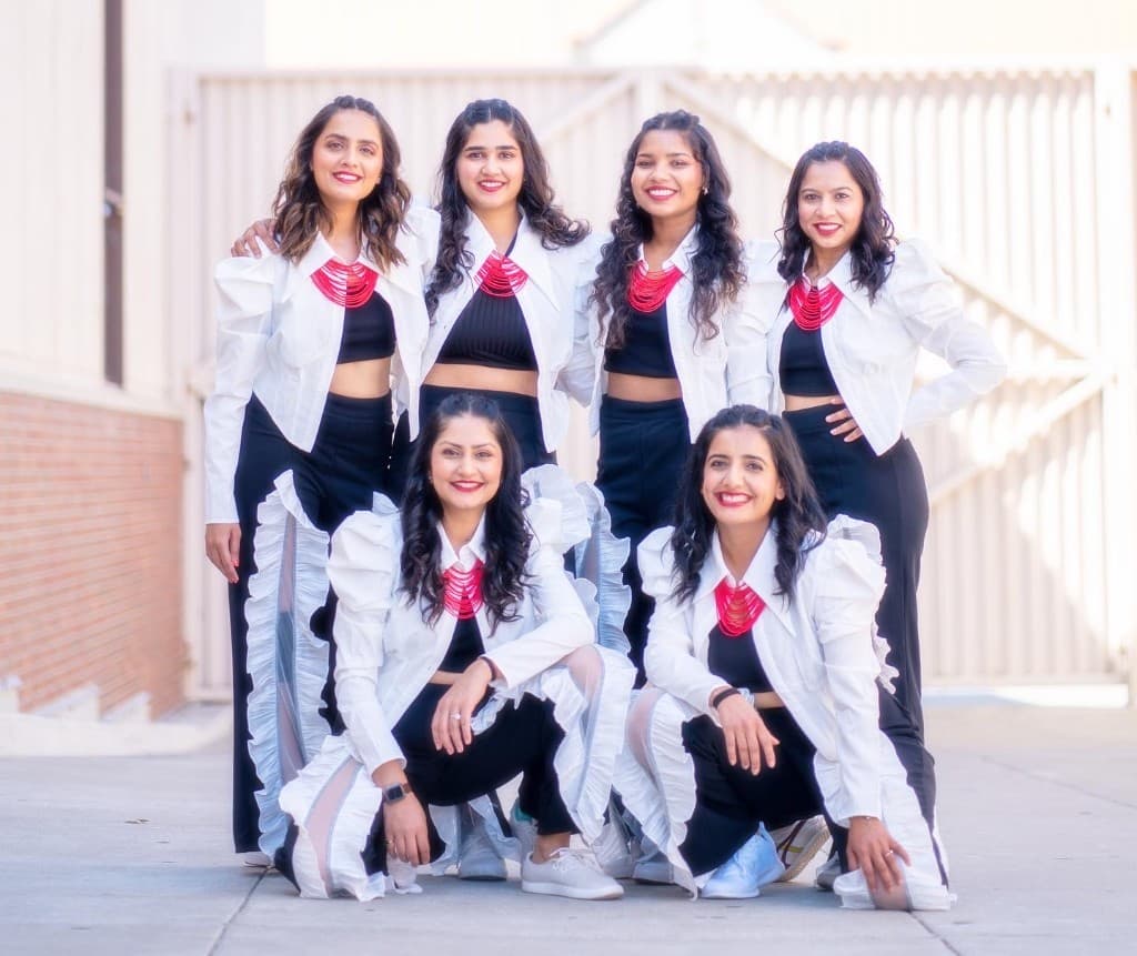 Performance group in white jackets mid-routine